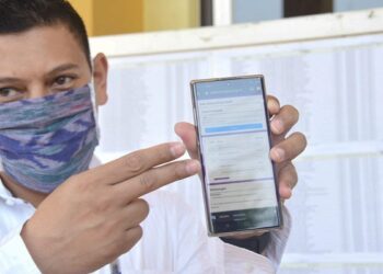 Abdullah Abu Bakar menunjukkan aplikasi pemantau bansos. Foto Humas