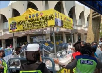 Anggota Polres Pasuruan membagikan minuman probiotik untuk menangkal corona. Foto: Bacaini