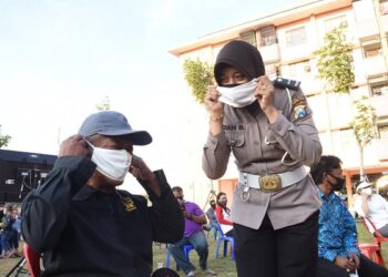 Anggota Polwan mengajarkan cara memakai masker kepada warga Kota Kediri. Foto: Kominfo