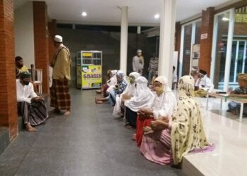 Warga penerima beras mengantre di ATM beras Masjid Al Khalid Kediri