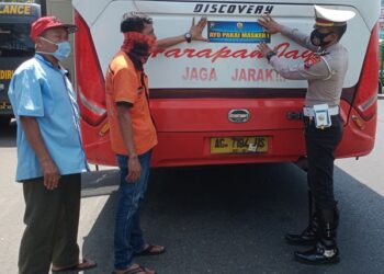 Pemasangan sticker di badan bus oleh Satlantas Polresta Kediri. Foto: Bacaini/Novira