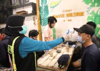 Pemeriksaan suhu tubuh di salah satu cafe di Jombang (Foto: bacaini.id/Syailendra)
