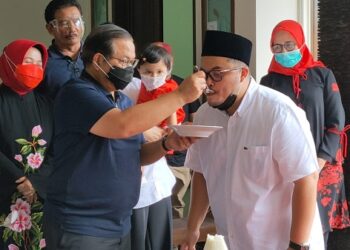 Pramono Anung menyuapi anaknya Hanidhito Himawan Pramana yang maju menjadi calon Bupati Kediri. Foto: Bacaini/BS