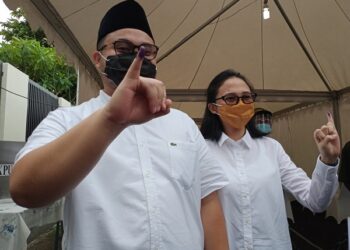 Dhito bersama istri usai melakukan pencoblosan suara di TPS 15 Tepus. Foto: Bacaini/Novira