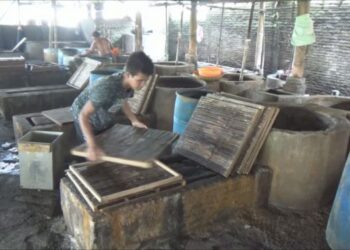 Pekerja pabrik tahu membersihkan alat-alat tahu (Foto:bacaini.id/Syailendra)