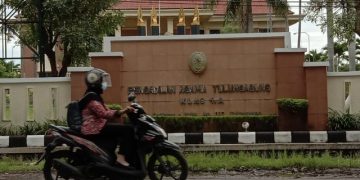 Seorang pengendara motor tengah melintasi depan kantor PA Tulungagung. Foto: Bacaini/Setiawan