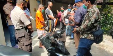 Tersangka (berbaju oranye) diamankan petugas kepolisian. Foto: Bacaini/AK.Jatmiko