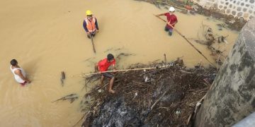 Petugas BPBD turun ke sungai bersihkan sampah yang menumpuk. Foto: Humas