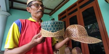 Imam Suhadi menunjukkan songkok dari bambu tali yang dibuatnya. Foto: Bacaini/Novira