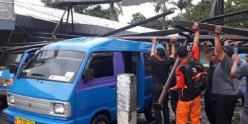 Angkot yang tertimpa atap runtuh usai diterjang hujan deras disertai angin kencang. Foto: Bacaini/A.Ulul
