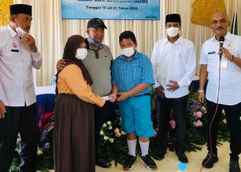 Nadia (baju pramuka) serahkan uang PIP-nya kepada Fatihur (baju batik). Foto: Bacaini/Rusdi