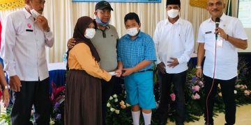 Nadia (baju pramuka) serahkan uang PIP-nya kepada Fatihur (baju batik). Foto: Bacaini/Rusdi