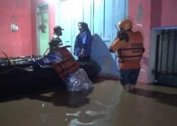 Tim BPBD bersama relawan mengevakuasi korban banjir. Foto: Bacaini/Syailendra