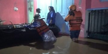 Tim BPBD bersama relawan mengevakuasi korban banjir. Foto: Bacaini/Syailendra
