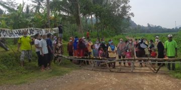 Puluhan warga  melakukan aksi tutup jalan rusak akibat aktivitas tambang. Foto: Bacaini/Aby