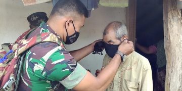 Anggota Koramil 0809/21 Puncu pasangkan masker pada seorang warga lansia. Foto: Bacaini/AK.Jatmiko