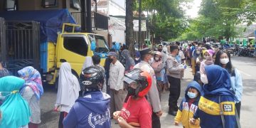 Antrean warga serbu paket minyak goreng murah mengular hingga ke jalan raya. Foto: Bacaini/Aby