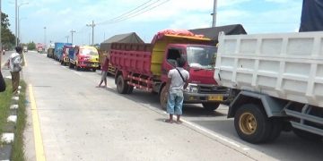 Ratusan truk sengaja diparkir di pinggir jalan pada aksi mogok kerja sopir truk di Nganjuk. Foto: Bacaini/Asep Bahar