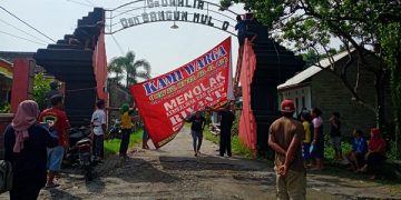 Aksi warga Desa Pojok, Kecamatan Wates, Kabupaten Kediri pasang spanduk penolakan kepulangan Riyanto. Foto: Bacaini/AK.Jatmiko