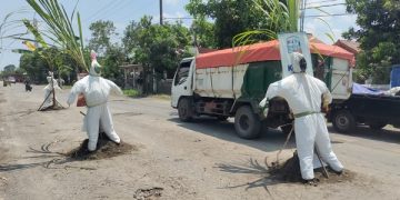 Boneka mirip tenaga kesehatan yang dipasang warga di jalan berlubang. Foto: Bacaini/AK.Jatmiko