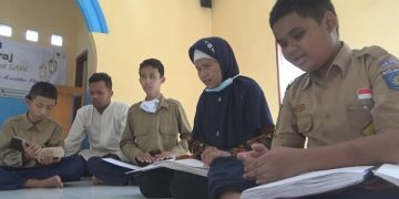 Para siswa tuna netra terlihat sungguh-sungguh membaca Al Quran braille. Foto: Bacaini/Syailendra