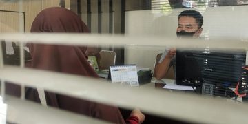 Ibu korban (berjilbab) saat melapor tindakan asusila ke Polres Kediri Kota. Foto: Bacaini/AK.Jatmiko