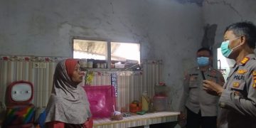 Petugas kepolisisan datang menyerahkan uang ganti rugi ke rumah warga. Foto: Bacaini/Rusdi