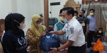 Manajer Humas KAI Daop 7 Madiun, Ixfan Hendriwintoko serahkan bantuan sembako kepada salah satu warga. Foto: Ist