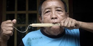 Sunyoto menunjukkan cara memainkan alat musik rinding buatannya. Foto: Bacaini/Setiawan
