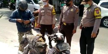 Anggota Polsek Kota Kediri mengevakuasi sepeda motor yang terbakar di depan SPBU Joyoboyo. Foto: Bacaini/AK.Jatmiko