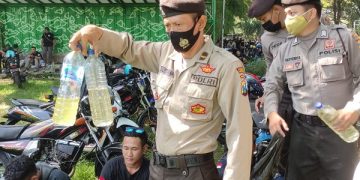 Polisi menunjukkan botol miras yang berhasil disita. Foto: Ist