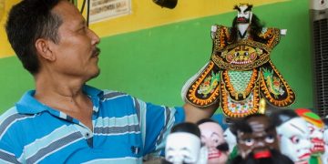Kuwato menunjukkan wayang potehi buatannya. Foto: Bacaini/Setiawan