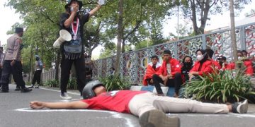 Aksi teatrikal mahasiswa GMNI Tulungagung di depan Kantor Pemkab Tulungagung. Foto: Bacaini/Setiawan