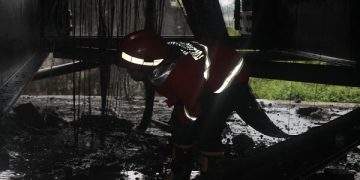 Petugas Damkar Tulungagung sedang memadamkan api di kolong Jembatan Ngujang. Foto: Bacaini/Setiawan