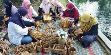 Ibu-ibu membuat handicraft dari limbah eceng gondok. Foto: Bacaini/Darman