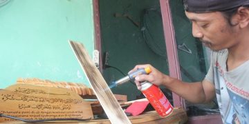 Abu Toyib menunjukkan cara membuat lukis bakar. Foto: Bacaini/Syailendra