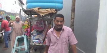 Dodik dan Sobah mendorong gerobak berdua menuju lokasi dagang. Foto: Bacaini/Syailendra