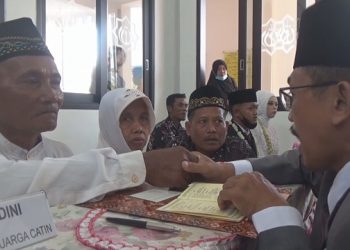 Ngadiran saat mengikrarkan ijab qobul dalam nikah massal yang digelar Polres Jombang. Foto: Bacaini/Syailendra