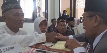 Ngadiran saat mengikrarkan ijab qobul dalam nikah massal yang digelar Polres Jombang. Foto: Bacaini/Syailendra