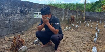 Seorang tenaga medis IKF dr Iskak Tulungagung berdoa di makam Mister X. Foto: Bacaini/Setiawan