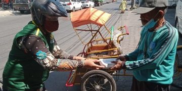 Si Jamal berikan paket makanan siap saji pada tukang becak di pinggir jalan. Foto: Ist