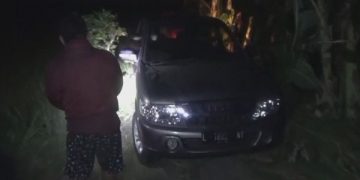 Mobil milik warga Surabaya yang terjebak di jalan setapak menuju makam. Foto: Bacaini/Syailendra