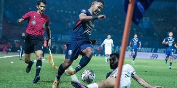 Gelandang Arema FC Gian Zola berjibaku dengan pemain PSS Sleman. Foto: Arema FC Official