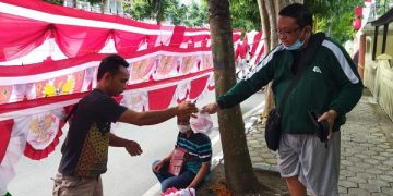 Asep saat melayani salah satu pembeli di lapaknya. Foto: Bacaini/Darman