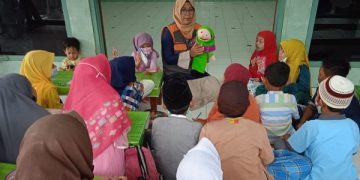 Tri Wulan Khoirun Ni’mah sedang memberikan dongeng kepada anak-anak di Tulungagung. Foto: Bacaini/Setiawan