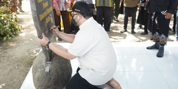 Mas Dhito menyematkan pesan pada batu prasasti di Sendang Sumber Agung. Foto: Ist