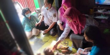 Petugas Dinsos Kota Kediri saat menyerahkan bansos kepada penerima. Foto: Ist