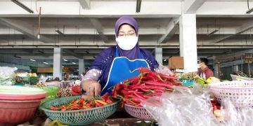 Salah seorang pedagang kebutuhan pangan dan sayur mayur di pasar tradisional Kota Kediri. Foto: Bacaini/Darman