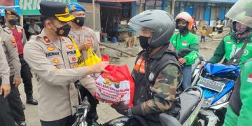 Waka Polres Kediri, Kompol Hendry serahkan bantuan satu paket sembako pada pengemudi ojek online. Foto: Bacaini/AK.Jatmiko