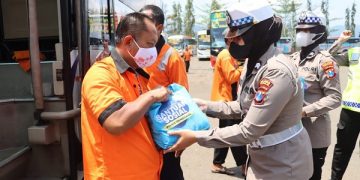 Anggota Polres Trenggalek serahkan sepaket sembako untuk sopir bus. Foto: Bacaini/Aby